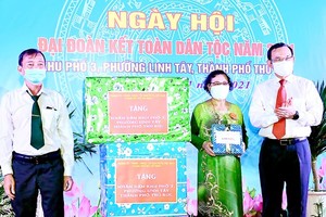Secretary of the HCMC Party Committee Nguyen Van Nen (R) presents gifts to people in the quarter No.3 of Thu Duc City’s Linh Tay Ward. (Photo: SGGP)