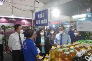 Vice Chairwoman of the HCMC People’s Committee Phan Thi Thang (C) visits a display booth in the conference. (Photo: SGGP)