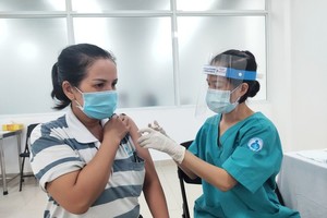 A healthcare worker gives a dose of Covid-19 vaccine to a resident.