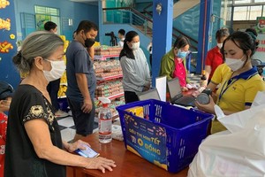 People are shopping at a market. (Photo: SGGP)