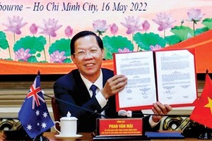 Chairman of the HCM City People’s Committee Phan Van Mai holds the signed agreement. (Photo: SGGP)