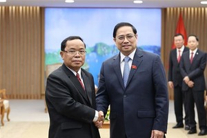 Prime Minister Pham Minh Chinh (R) receives President of the Lao State Inspection Authority Khamphan Phommaphat. (Photo: VNA)