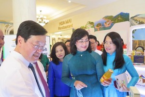 Vice Chairwoman of the HCMC People’s Committee Phan Thi Thang visits a display booth of Nghe An Province's local products. (Photo: SGGP)