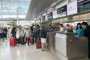 Passengers complete the check-in process at check-in counters at an airport.