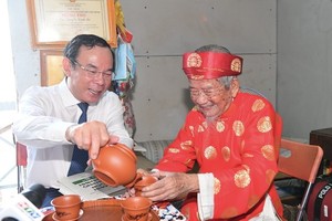 Secretary of the HCMC Party Committee Nguyen Van Nen (L) expresses his deep gratitude to the researcher for his great contributions and valuable research works to the country in general and the city particularly.