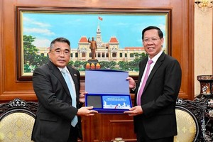 Chairman of the HCMC People’s Committee Phan Van Mai (R) offers a gift to Philippine Ambassador to Vietnam, Meynardo LB. Montealegre. (Photo: SGGP)