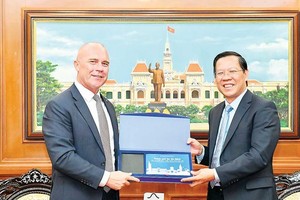 Chairman of the HCMC People’s Committee Phan Van Mai (R) presents a gift to New Zealand Consul-General in the city, Joseph Nelson.