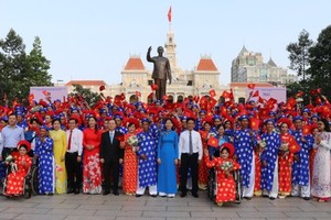 City's leaders and worker couples offer lowers to President Ho Chi Minh at his statue at Ho Chi Minh Statue Park in front of the City Hall .