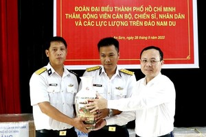 Vice Secretary of the HCMC Party Committee Nguyen Van Hieu (R) offer a gift to representatives of  the Radar Station 600.