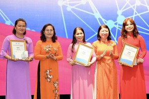 Chairwoman of the HCMC People’s Council Nguyen Thi Le (2nd, L) and head of the task force in the South of the Vietnam Women's Union (VWU) Central Committee, Tran Thi Huyen Thanh (2nd, R) offer prizes to winners of a contest titled "Women's Confidence in B