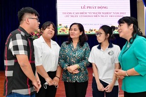 Chairwoman of the HCMC People's Council Nguyen Thi Le (C) and  Chairwoman of the VFF in HCMC Tran Kim Yen (R) meet students who receive assistance.