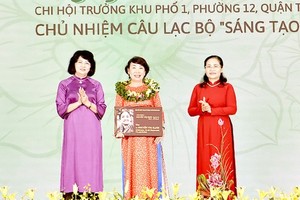Former Vice President Dang Thi Ngoc Thinh (L) and Chairwoman of the HCMC People’s Council Nguyen Thi Le (R) offer the Nguyen Thi Dinh Awards 2022 to a typical woman.