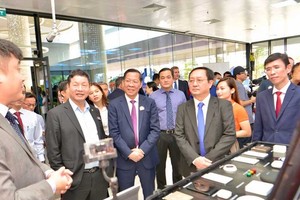 Chairman of the HCMC People’s Committee Phan Van Mai (3rd, L) and and Minister of Science and Technology Huynh Thanh Dat (2nd, R) visit a display booth of high-tech products at the event.