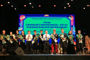 Vice Secretary of the HCMC Party Committee Nguyen Van Hieu (5th, R) and Deputy Minister of Culture, Sports and Tourism Doan Van Viet (5th, L) offers flowers to artists in the opening ceremony of the second “Ho Do" International Music Festival 2022.