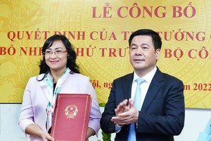 Minister of Industry and Trade Nguyen Hong Dien (R) hands over the PM’s appointment decision to Deputy Minister of Industry and Trade Phan Thi Thang on December 21. (Photo: SGGP)