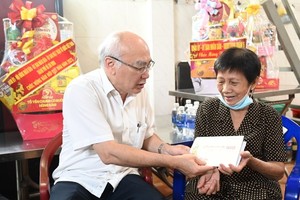 Head of the Propaganda and Education Board of the City Party Committee Phan Nguyen Nhu Khue (L) offers present to Ms. Luong Ha Nu. (Photo: SGGP)