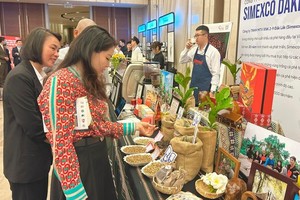 Visitors visit a display booth for coffee. (Photo: SGGP)
