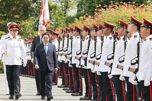 Singaporean Prime Minister Lee Hsien Loong hosts the official welcome ceremony for Prime Minister Pham Minh Chinh (front). (Photo: VNA)