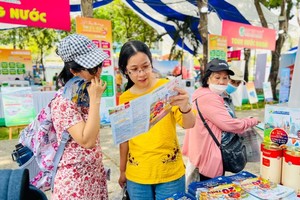 Visitors learn about information of domestic and foreign tours at a booth in the festival. (Photo: SGGP)