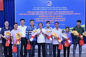 Deputy Director of the HCMC Department of Natural Resources and Environment Vo Trung Truc (5th, R) and Chairman of the People’s Committee of Binh Chanh District Vo Duc Thanh (3rd,L) offer gifts to affected families. (Photo: SGGP)