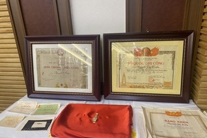 Martyr Nguyen Thi Trien’s familiy hands over her certificates of merit and a watch presented by Uncle Ho to the Ho Chi Minh Museum on May 18. (Photo: SGGP)