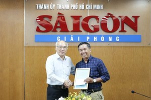 Head of the Propaganda and Education Board of the HCMC Party Committee Phan Nguyen Nhu Khue (L) presents a compliment letter to journalist Pham Hoai Nam of the SGGP Newspaper for his articles on fighting against wrong and hostile views. (Photo: SGGP)