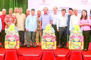 Former deputy Prime Minister Truong Hoa Binh (C) and lHCMC's leaders offer presents to the representative board of the Muslim community in the city, management boards of mosques, and oratories. (Photo: SGGP)
