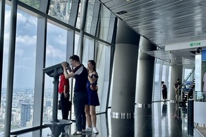 Foreign visitors enjoy the panoramic view of HCMC at the Saigon Skydeck. (Photo: VNA)