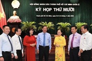 Chairpersons of the HCMC People's Council and People's Committee talk with delegates at the meeting. (Photo: SGGP)