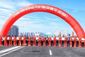 Prime Minister Pham Minh Chinh and delegates cut the ribbon to inaugurate the second-phase Vinh Tuy bridge. (Photo: VNA)