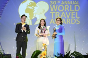 Director of the HCMC Tourism Department Nguyen Thi Anh Hoa (C) receives the awards honoring the city's tourism sector. (Photo: SGGP)