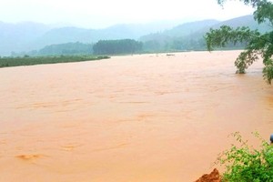 A bridge crossing the Ngan Sau River in Rao Tre mountainous village in Huong Lien Commune of Huong Khe District, Ha Tinh Province is submerged in floodwaters. (Photo: SGGP)