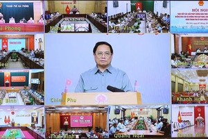 Prime Minister Pham Minh Chinh (centre) chairs the anti-IUU teleconference from Hanoi on October 7. (Photo: VNA)