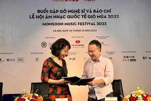MMF founder and director Quoc Trung (right), and a representative of Techcombank, To Thi Phuong Thuy, exchange the signed document on the establishment of the 'Inspire Your Next Fund' to support Vietnamese young and talented artists. (Photo: VNA)