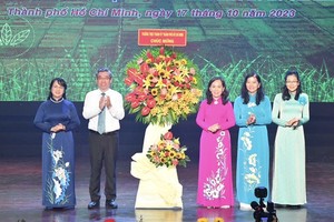 Vice Secretary of the HCMC Party Committee Nguyen Phuoc Loc (2nd, L) and Chairwoman of the Vietnam Fatherland Front Committee in HCMC Tran Kim Yen (L) offer flowers to the HCMC Farmers’ Association on the 93rd anniversary of the founding of the Vietnam Farmers' Association (October 14, 1930-2023). (Photo: SGGP)