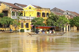 People take boats to ride around flooded streets.