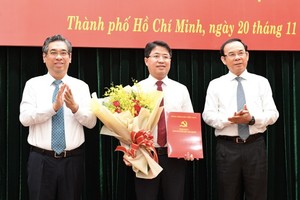 Secretary of the HCMC Party Committee Nguyen Van Nen (R) and Vice Secretary of the Party Committee of the city Nguyen Phuoc Loc (L) congratulate Chief of the Office of the HCMC Party Committee Pham Hong Son. (Photo: SGGP)