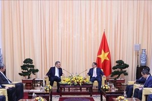 Prime Minister Pham Minh Chinh (R) receives Chinese Minister of Commerce Wang Wentao. (Photo: VNA)