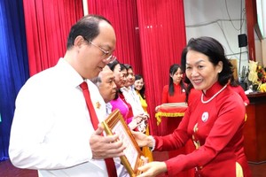 President of the Vietnam Red Cross Society (VRC) Central Committee Bui Thi Hoa offers the “For the Cause of Humanity” medal to Vice Secretary of the HCMC Party Committee Nguyen Ho Hai. (Photo: SGGP)