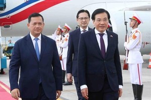 Cambodian PM Samdech Moha Bovor Thipadei Hun Manet (left) is welcomed by Minister - Chairman of the Government Office Tran Van Son (front, right) at Noi Bai International Airport on December 11 morning. (Photo: VNA)
