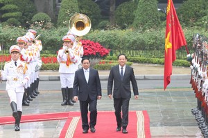 PM Pham Minh Chinh (L) and his Lao counterpart Sonexay Siphandone review the guard of honor at the welcome ceremony in Hanoi on January 6 morning. (Photo: SGGP)