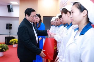 Prime Minister Pham Minh Chinh presents gifts to workers. (Photo: VNA)