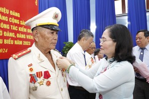 Chairwoman of the HCMC People’s Council Nguyen Thi offers Party membership badges to cadres in Cu Chi District. (Photo: SGGP)