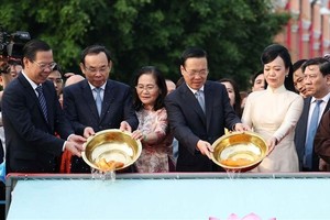 President Vo Van Thuong (second, right, front), his spouse and leaders of HCMC release carps as part of the “Ong Cong, Ong Tao” worshipping ritual. (Photo: VNA)