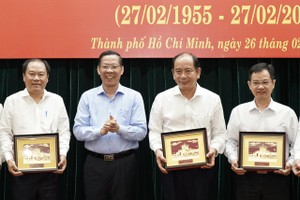 Chairman of the HCMC People’s Committee Phan Van Mai (2nd, L) congratulates healthcare professionals. (Photo: SGGP)