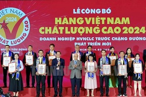 Chairman of the HCMC People’s Committee Phan Van Mai (5th, L) and Mr. Phan Thanh Binh (6th, L) offer certificates of title of high-quality Vietnamese products to enterprises. (Photo: SGGP)