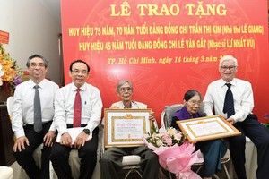 Secretary of the HCMC Party Committee Nguyen Van Nen (2nd, L), Secretary of the Party Committee of Binh Duong Province Nguyen Van Loi(R) and Vice Secretary of the HCMC Party Committee Nguyen Phuoc Loc (L) offer Party membership badges to the artist couple Le Giang and Lu Nhat Vu. (Photo: SGGP)