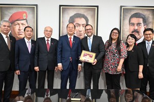 The HCMC's delegation offers a gift to Minister of Foreign Affairs of Venezuela Yvan Gil Pinto. (Photo: SGGP)