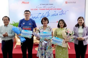 Vice Chairman of the HCMC Journalists Association Mai Ngoc Mai Ngoc Phuoc (L) and Ms. Ly Viet Trung, editor-in-chief of the Phu Nu TPHCM (HCMC Women) Newspaper (R) offer awards to winners. (Photo: SGGP)