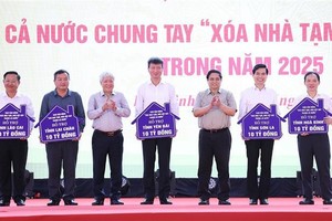 From right: Prime Minister Pham Minh Chinh (3rd) and Chairman of the Vietnam Fatherland Front Central Committee Do Van Chien (5th) hand over the tokens of funds allocated to assist in the removal of temporary and ramshackle houses across several provinces. (Photo: VNA)